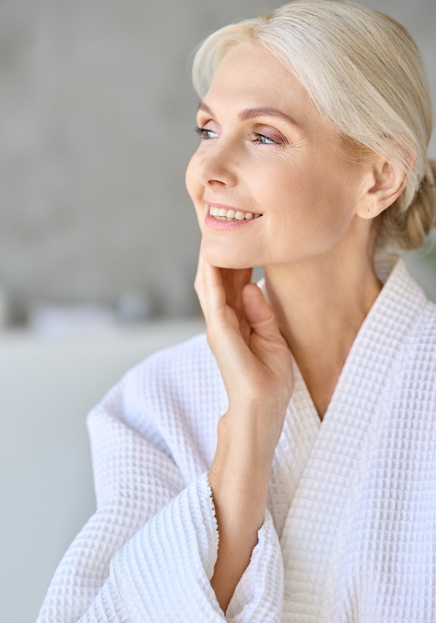 Portrait of smiling mid age woman looking away on spa procedures.