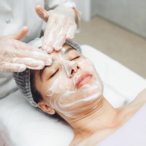 the cosmetologist cleanses the skin with foam.